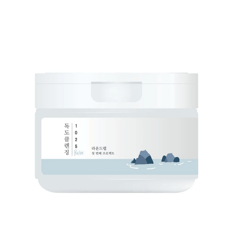 En stängd vit burk av 1025 Dokdo Cleansing Balm med minimalistiskt havstema på etiketten, mot en vit bakgrund.